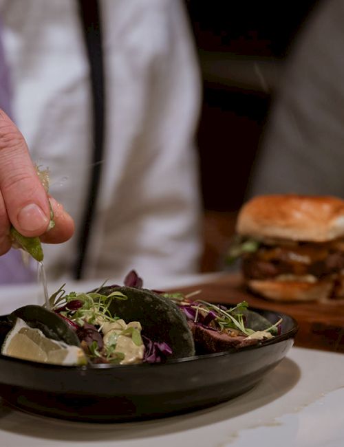 A sliced rectangular pizza topped with mushrooms, cheese, and arugula on a wooden board.
